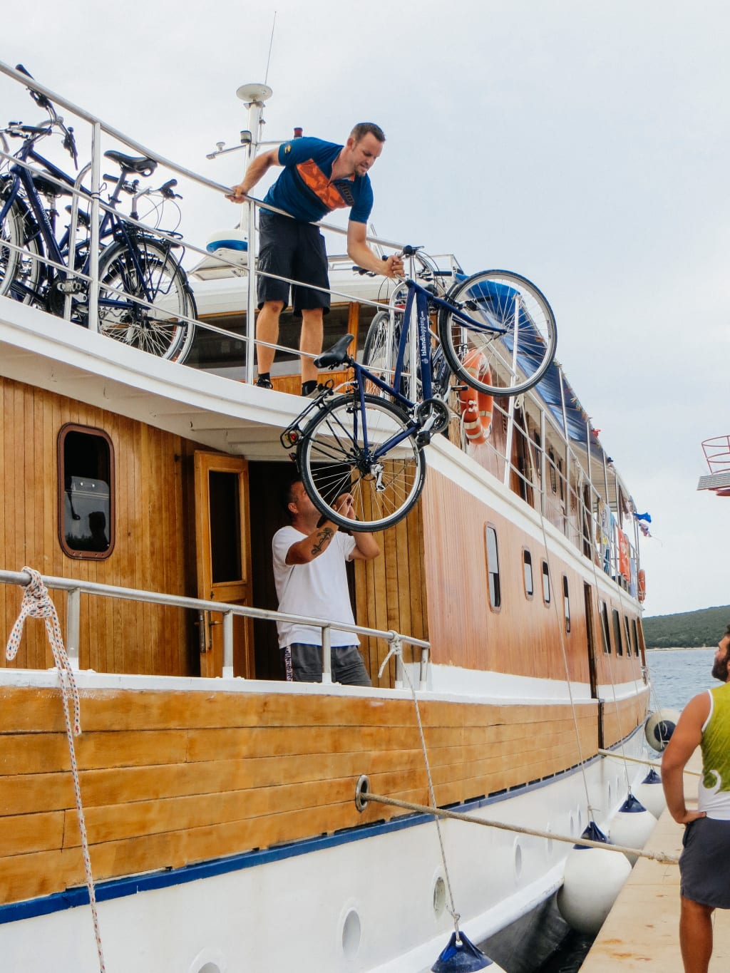 Menschen, die Fahrräder von einem Boot ausladen, Fahrrad- und Bootsfahrt, Kroatien, "Girolibero“-Fahrrad- und Bootsfahrten